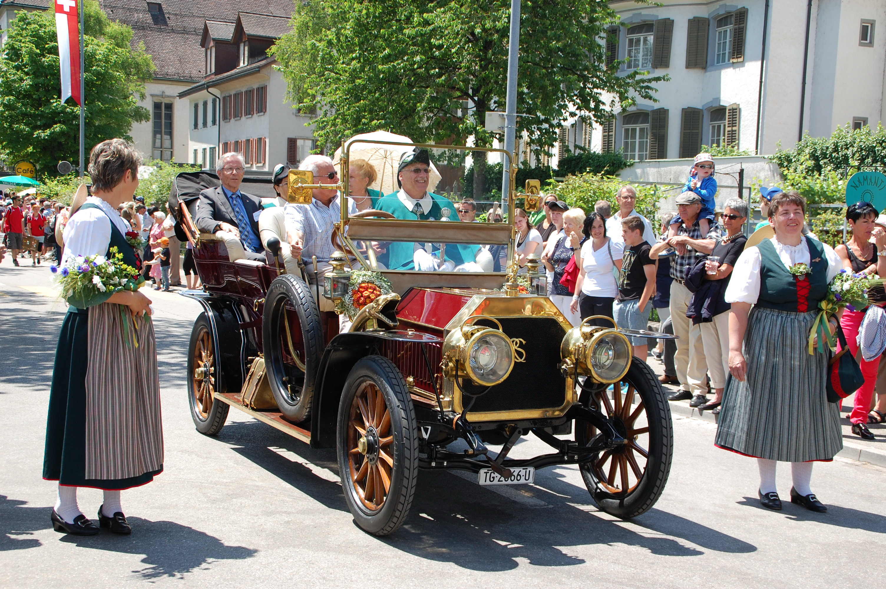Regierungspräsident Claudius Graf grüsst aus dem blumengeschmückten Oldtimer.